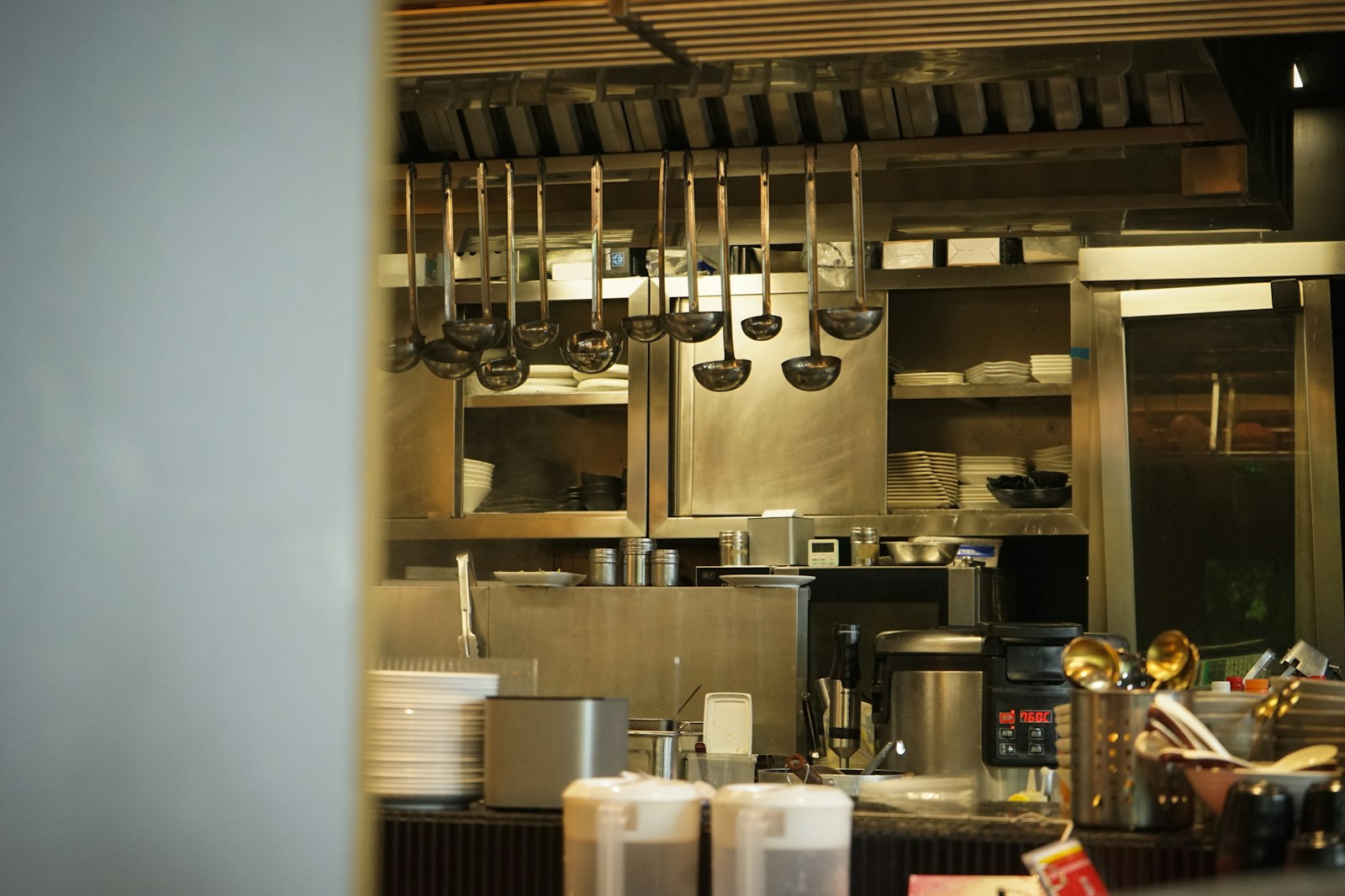 Stainless steel commercial kitchen line with overhead extraction